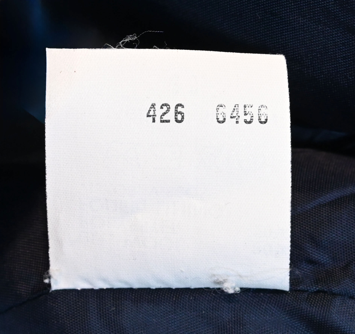 Kavaj, uniform, dammodell. Mörkblå tyg av 80% ull och 20 % polyester. Enkelknäppning med två guldfärgade metallknappar. Två midjefickor och en bröstficka på vänster sida, samt en innerficka. Kavajslaget och fickornas kanter har vinröda passpoaler. Design av Getti S.P.A.