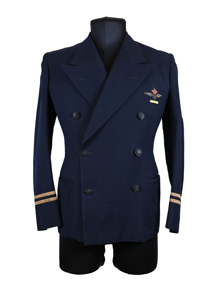 Kavaj i herrmodell, uniform från flygbolaget KLM Royal Dutch Airlines. Har tidigare tillhört Carl Gustaf Von Rosen. Mörkblå ylle med dubbelknäppning. Med KLMs emblem på vänster sida samt två galoner vid var ärmslut.
