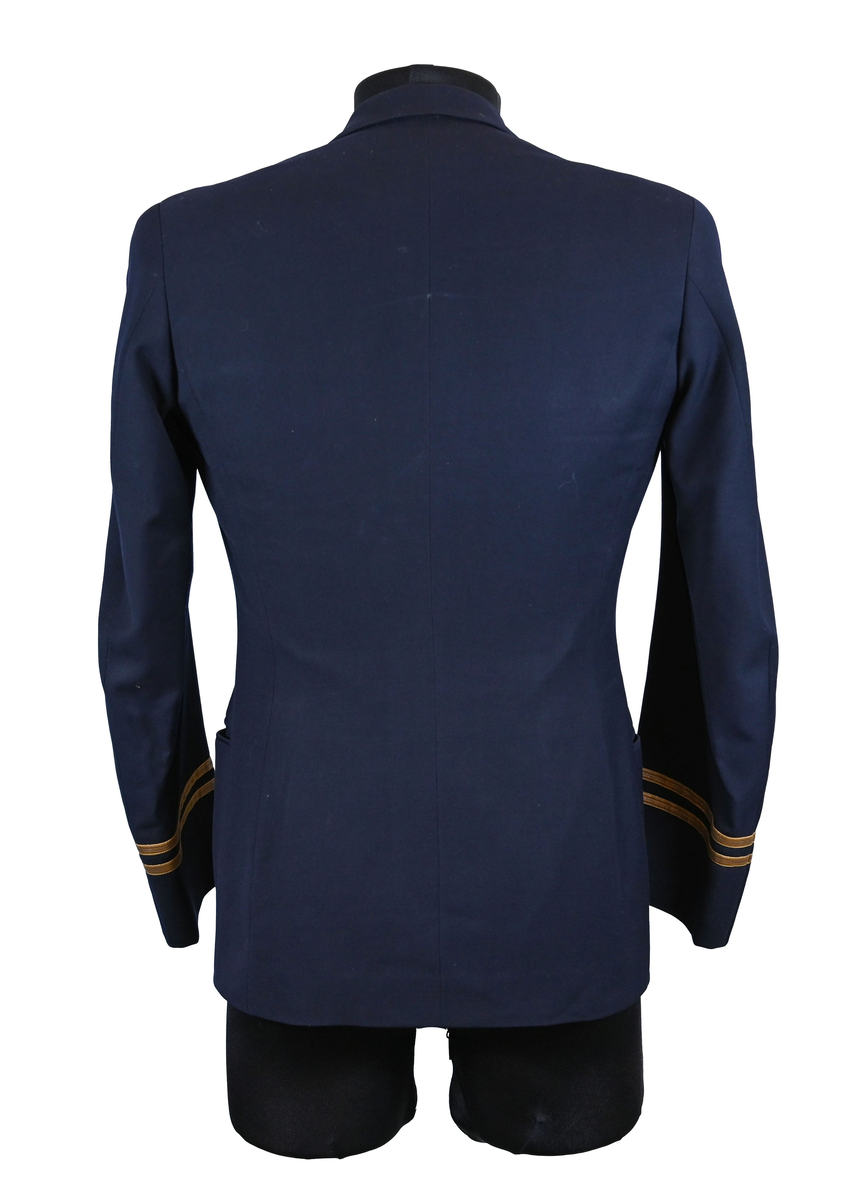 Kavaj i herrmodell, uniform från flygbolaget KLM Royal Dutch Airlines. Har tidigare tillhört Carl Gustaf Von Rosen. Mörkblå ylle med dubbelknäppning. Med KLMs emblem på vänster sida samt två galoner vid var ärmslut.