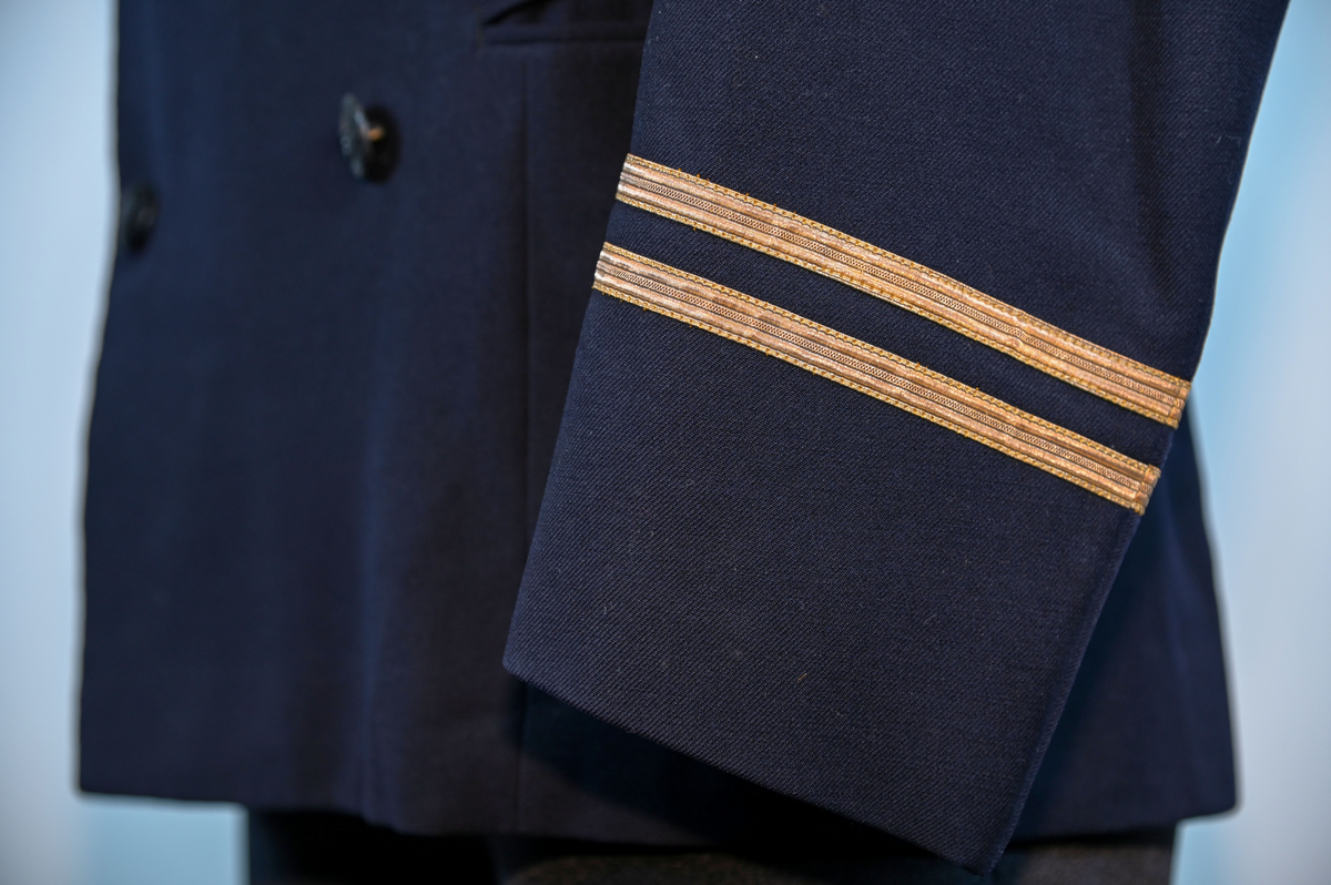 Kavaj i herrmodell, uniform från flygbolaget KLM Royal Dutch Airlines. Har tidigare tillhört Carl Gustaf Von Rosen. Mörkblå ylle med dubbelknäppning. Med KLMs emblem på vänster sida samt två galoner vid var ärmslut.