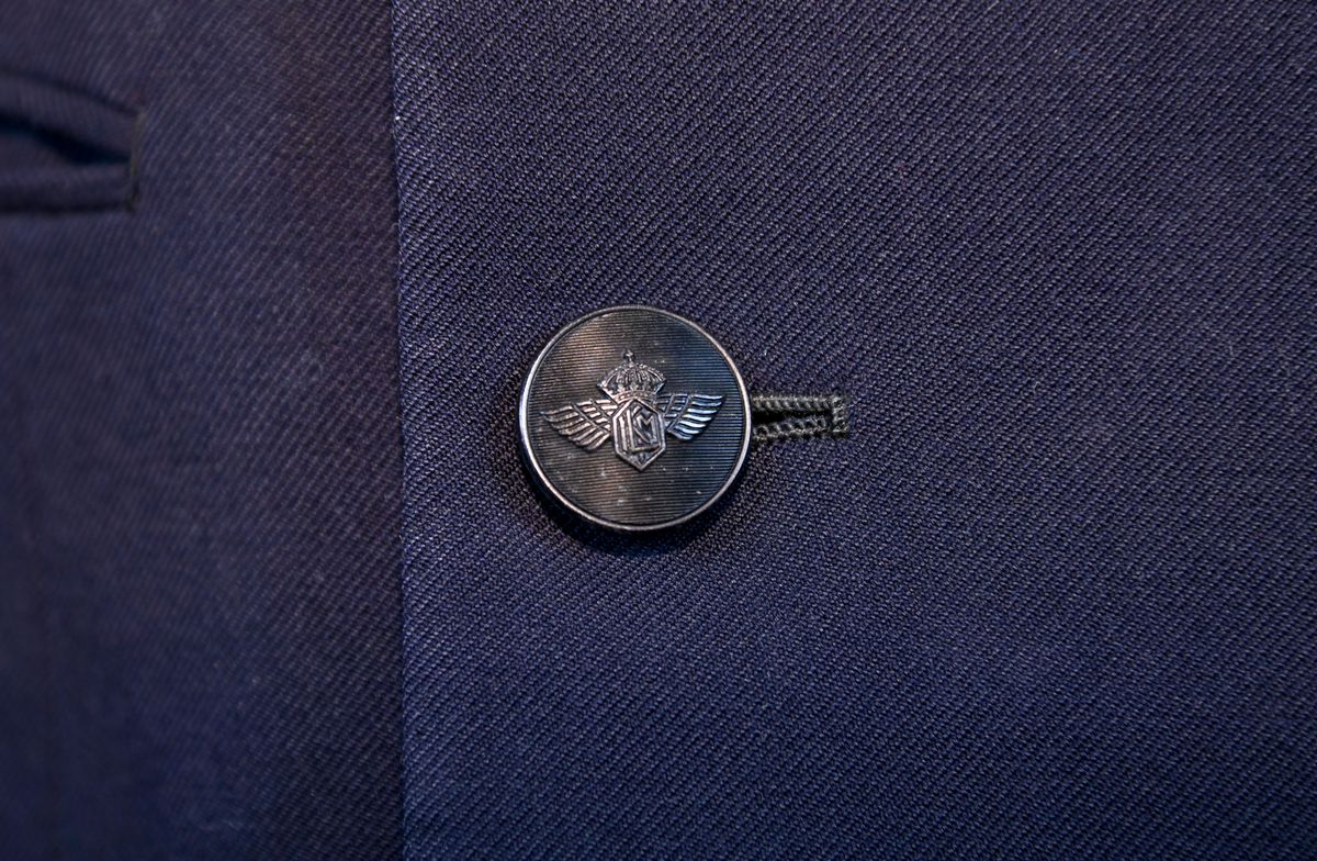 Kavaj i herrmodell, uniform från flygbolaget KLM Royal Dutch Airlines. Har tidigare tillhört Carl Gustaf Von Rosen. Mörkblå ylle med dubbelknäppning. Med KLMs emblem på vänster sida samt två galoner vid var ärmslut.
