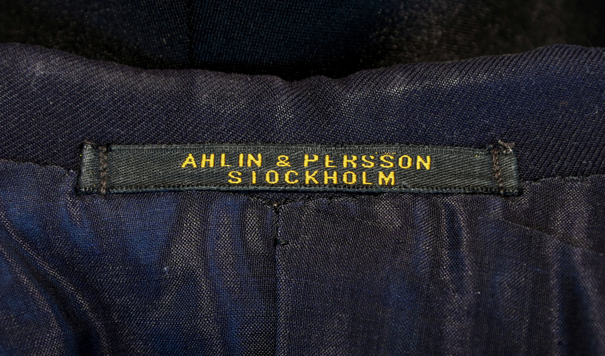 Kavaj i herrmodell, uniform från flygbolaget KLM Royal Dutch Airlines. Har tidigare tillhört Carl Gustaf Von Rosen. Mörkblå ylle med dubbelknäppning. Med KLMs emblem på vänster sida samt två galoner vid var ärmslut.