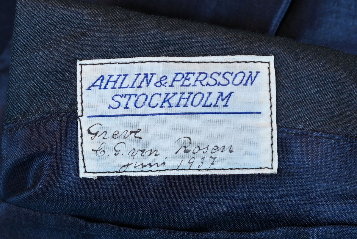 Kavaj i herrmodell, uniform från flygbolaget KLM Royal Dutch Airlines. Har tidigare tillhört Carl Gustaf Von Rosen. Mörkblå ylle med dubbelknäppning. Med KLMs emblem på vänster sida samt två galoner vid var ärmslut.