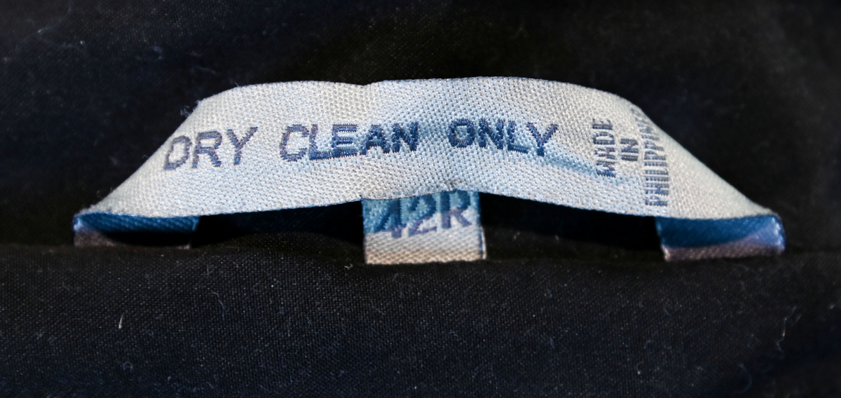 Fodrad överrock i trenchcoat-modell för flygbolagspersonal hos Delta Air Lines. Rocken har två ytterfickor samt en innerficka. Rocken består av skalrock samt löstagbart foder genom dragkedja. Både skalrock och foder är svarta och skalrocken är sydd med raglanärm. Enkel knäppning med fem svarta plastknappar samt två svarta plastknappar vid vardera ärmslut.

Storlek 42 R