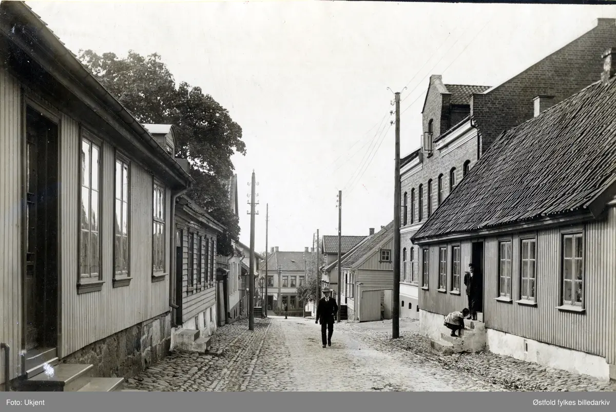 Gateparti fra Værlegata i Moss, postkort ca. 1910. Til høyre Agnalt-gården, bygd 1825. Den store murbygningen er fra 1878. Gården til venstre ble bygd 1856. og gårdene nedenfor i 1830-åra. Barn på trappa.