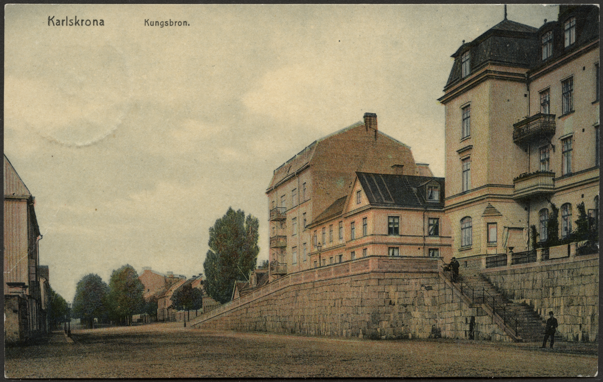 Vykort på Kungsbron Karlskrona.
Apparaljer i Karlskrona, den vackraste och bäst bibehållna är den vid Kungsbron, vilken från Alamedan förmedlar trafiken till Hästkvarsgatan. En ståtlig anläggning byggd 1861, försågs den år 1868 med ett vackert bröstvärn av huggen kalksten.
