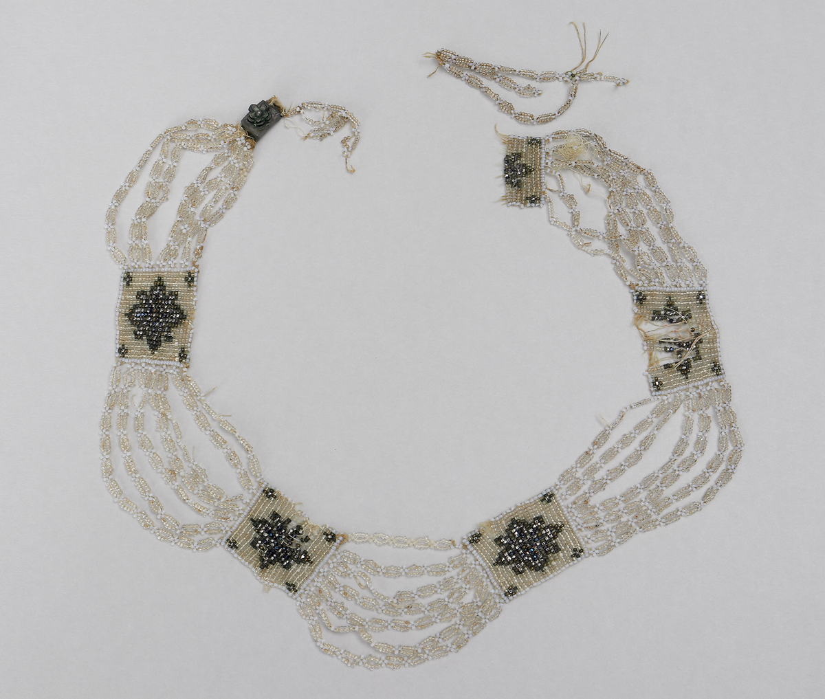Halsband (M 3525 a) består av stålpärlor med silverlås. 

Halsband (M 3525 b) består av glaspärlor i olika färger (vita, svagt gröna, metallglänsande och ofärgade). Det har fem rektangulära pärlbroderier sammanbundna med sju länkar vardera. Lås saknas. Broderiplattornas storlek 28 x 24 mm.