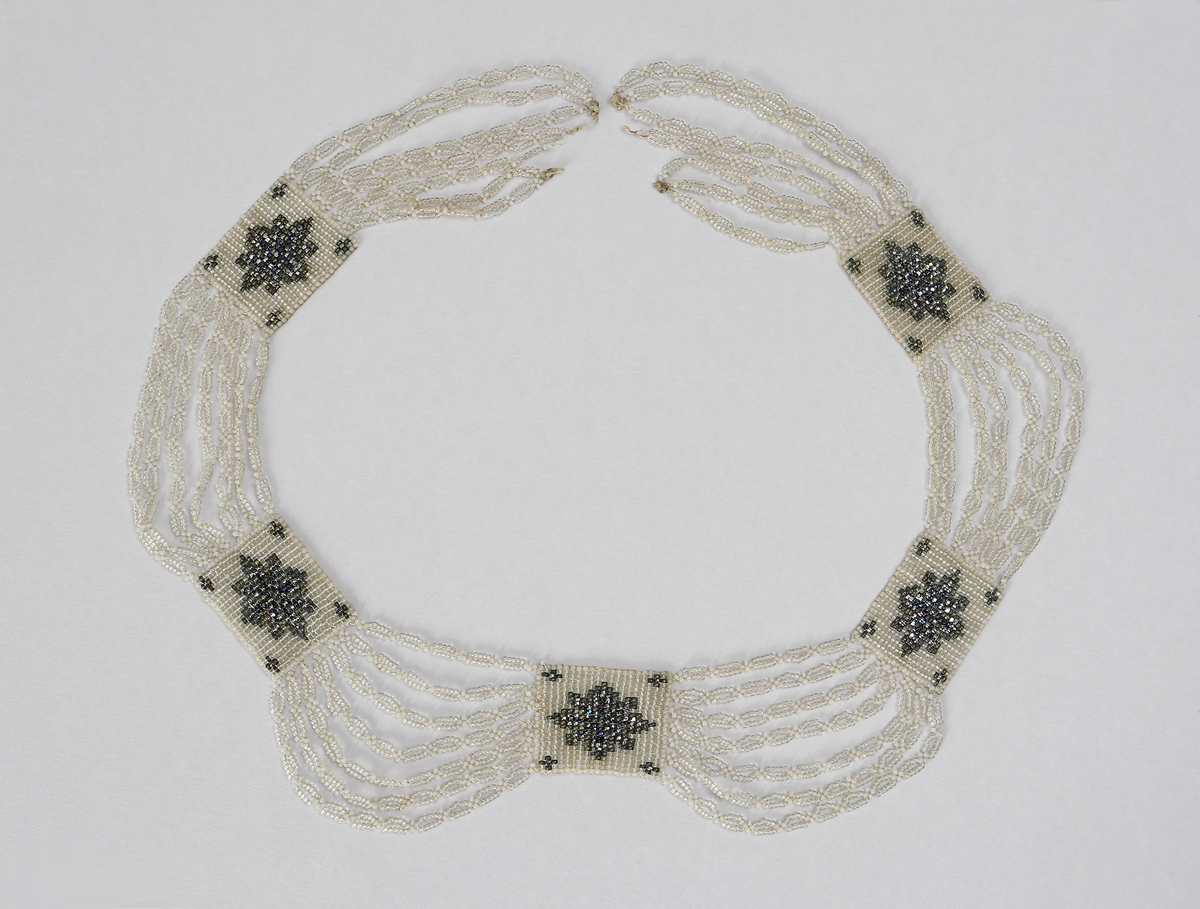 Halsband (M 3525 a) består av stålpärlor med silverlås. 

Halsband (M 3525 b) består av glaspärlor i olika färger (vita, svagt gröna, metallglänsande och ofärgade). Det har fem rektangulära pärlbroderier sammanbundna med sju länkar vardera. Lås saknas. Broderiplattornas storlek 28 x 24 mm.