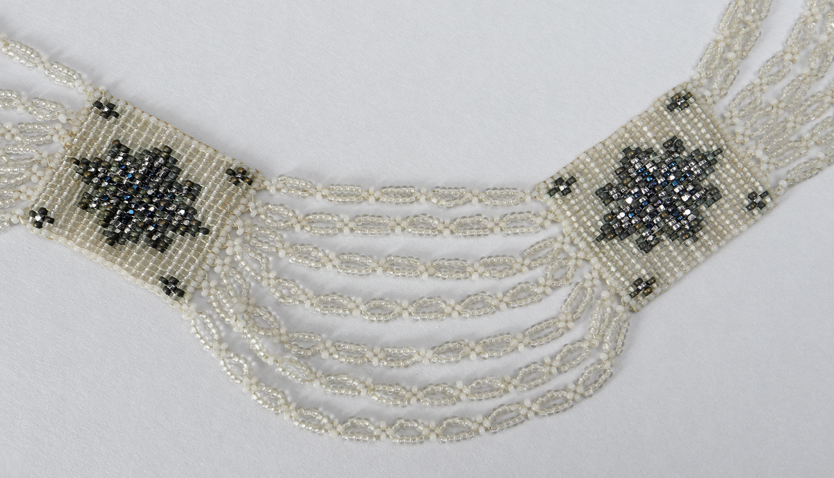 Halsband (M 3525 a) består av stålpärlor med silverlås. 

Halsband (M 3525 b) består av glaspärlor i olika färger (vita, svagt gröna, metallglänsande och ofärgade). Det har fem rektangulära pärlbroderier sammanbundna med sju länkar vardera. Lås saknas. Broderiplattornas storlek 28 x 24 mm.