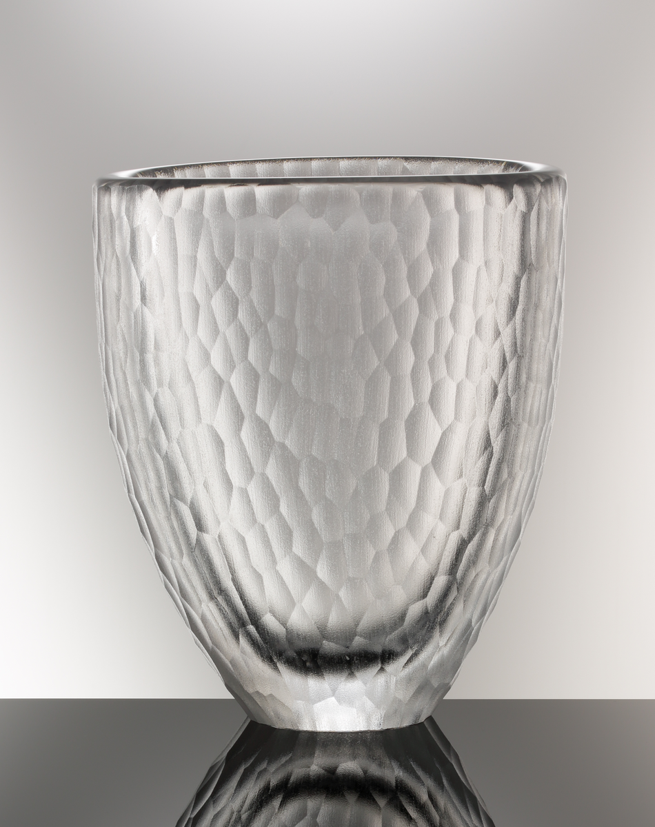 Formgivare: Jan Johansson. Vas. Tjockväggig oval form, avsmalnad mot botten. 
Utförd med yttäckande fjällslipad matt dekor.