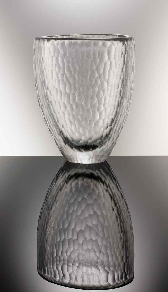 Formgivare: Jan Johansson. Vas. Tjockväggig oval form, avsmalnad mot botten. 
Utförd med yttäckande fjällslipad matt dekor.