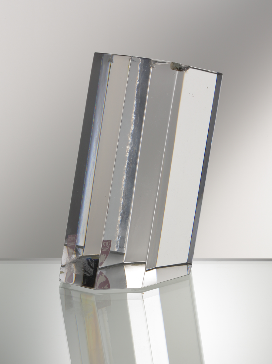 Formgivare: Jan Johansson. Skulptur "Pisa". Massivt glas med åtta stående fasetter, lutande från basen.