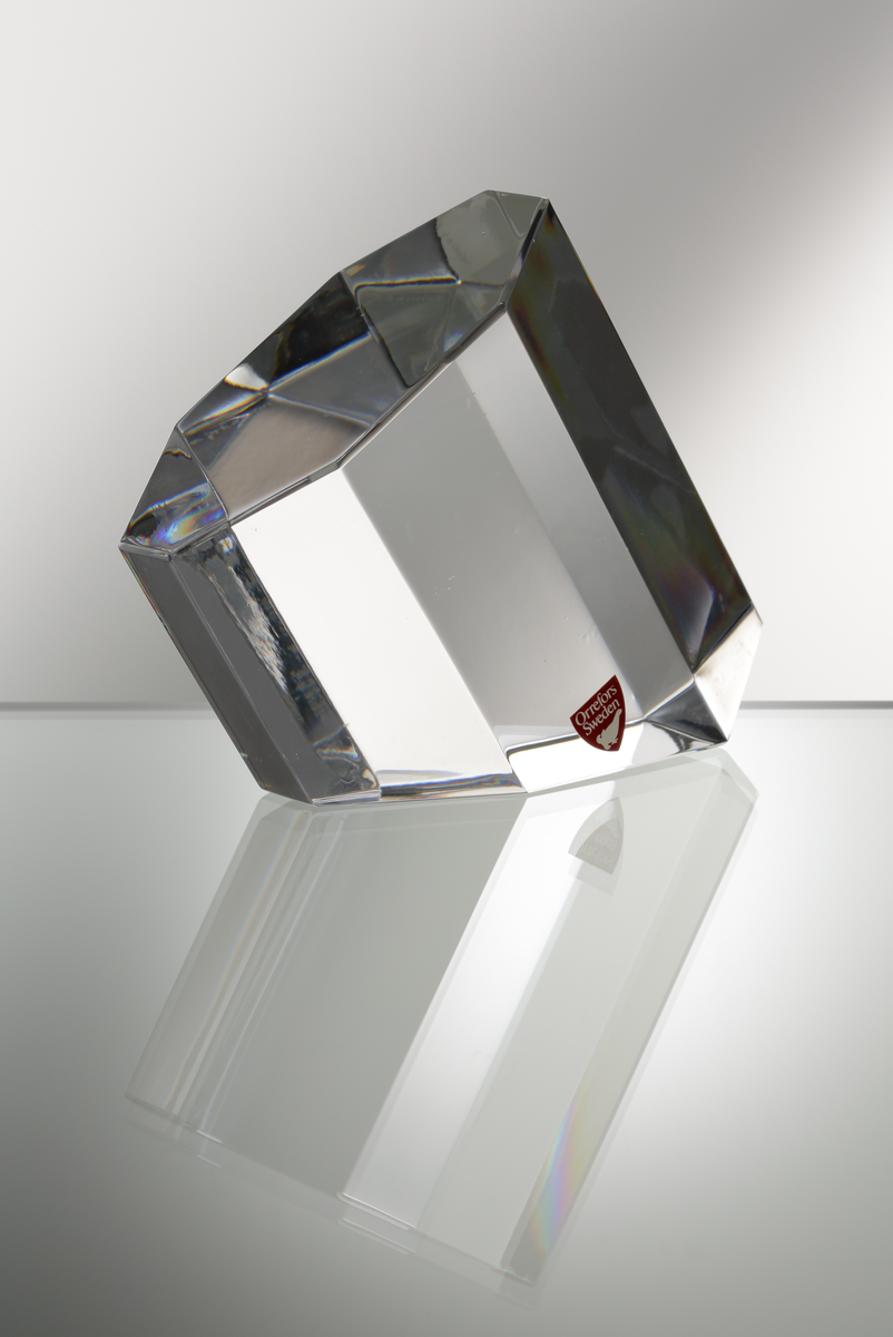 Formgivare: Jan Johansson. Skulptur "Oktav". Massivt glas med åttkantig fasetterande form och diagonalt slipad bas.
