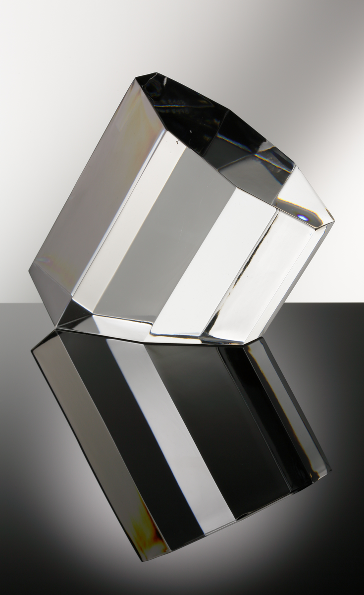 Formgivare: Jan Johansson. Skulptur "Oktav". Massivt glas med åttkantig fasetterande form och diagonalt slipad bas.
