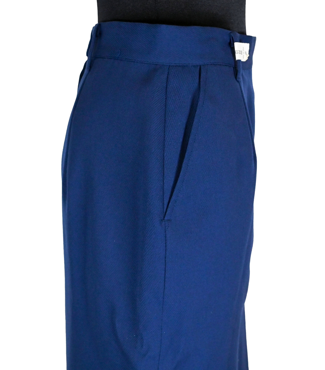 Kjol i mörkblå textil till ämbetsdräkt för kvinnlig personal vid Luftfartverket. Kjolen har två enkla framfickor. Längs midjan sitter fyra hällor för bälte. I bak i plaggets nederkant finns ett gångveck. Kjolen stängs i bak med dragkedja och knapp. Fodringen är mörkblå. 

På insidan i bak sitter två lappar med information om tillverkare och storlek. På ena lappen finns även Luftfartsverkets logga. Kjolen är producerad av Confetti i storlek C40. I en av hällorna sitter en papperslapp med nummer 8632. På denna har texten 3/10 påförts i bläck.