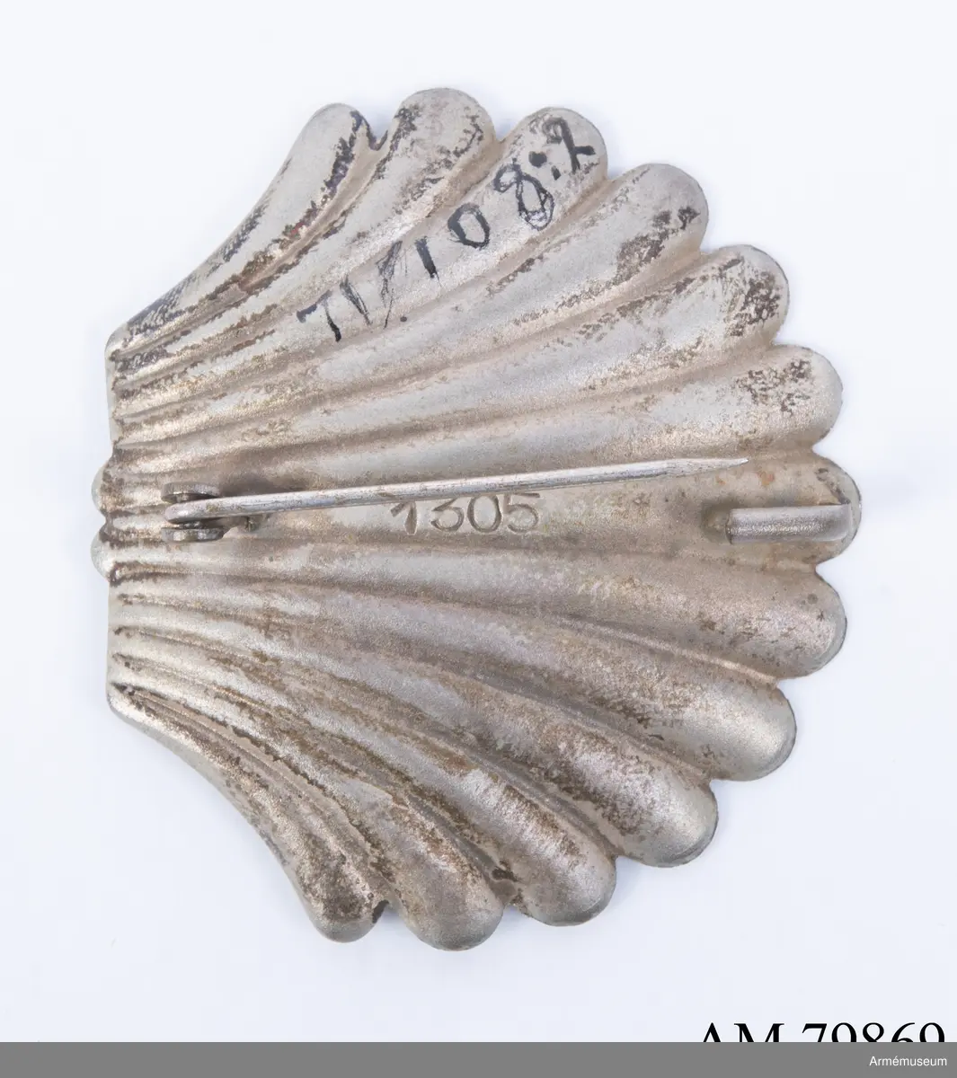 Påvliga Heliga Gravens orden, kommendörstecken i svart band. 
Miniatyr och knapp. Ordenstecknet i form av pilgrimssnäcka tilldelades ordensriddare som genomfört en pilgrimsresa till det heliga landet.

Förvaras i samhörande etui.