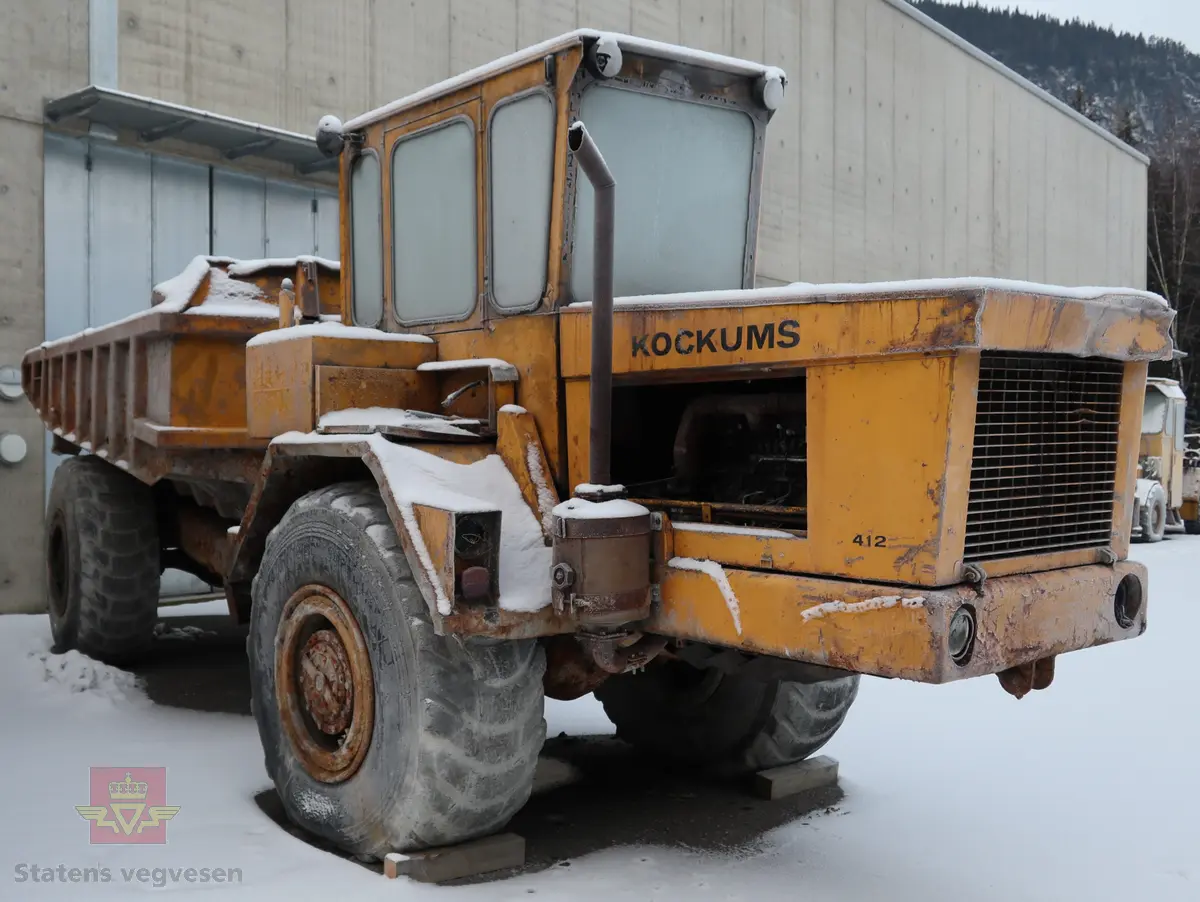 Gul midjestyrt dumper med 4 hjul, 2 akslinger. 6-sylindret diesel drevet forbrenningsmotor med volum 1 L som yter 3 hk. Motoren er av typen Cu. Dumperen har tipp. Merking fra produsenten og forhandleren i Norge.