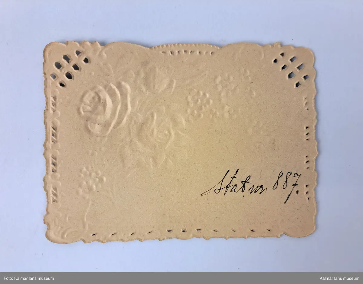 KLM 46816:18. Varuprov, trycksak. Tryck på vitt papper, med blommönster i rosa, grönt och blått. Påskrift baksida i bläck: Stat. nr 887.