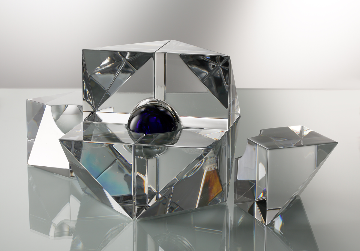 Formgivare: Jan Johansson. Skulptur i massivt klarglas, sjudelad geometrisk form med kula i blåtonat glas.