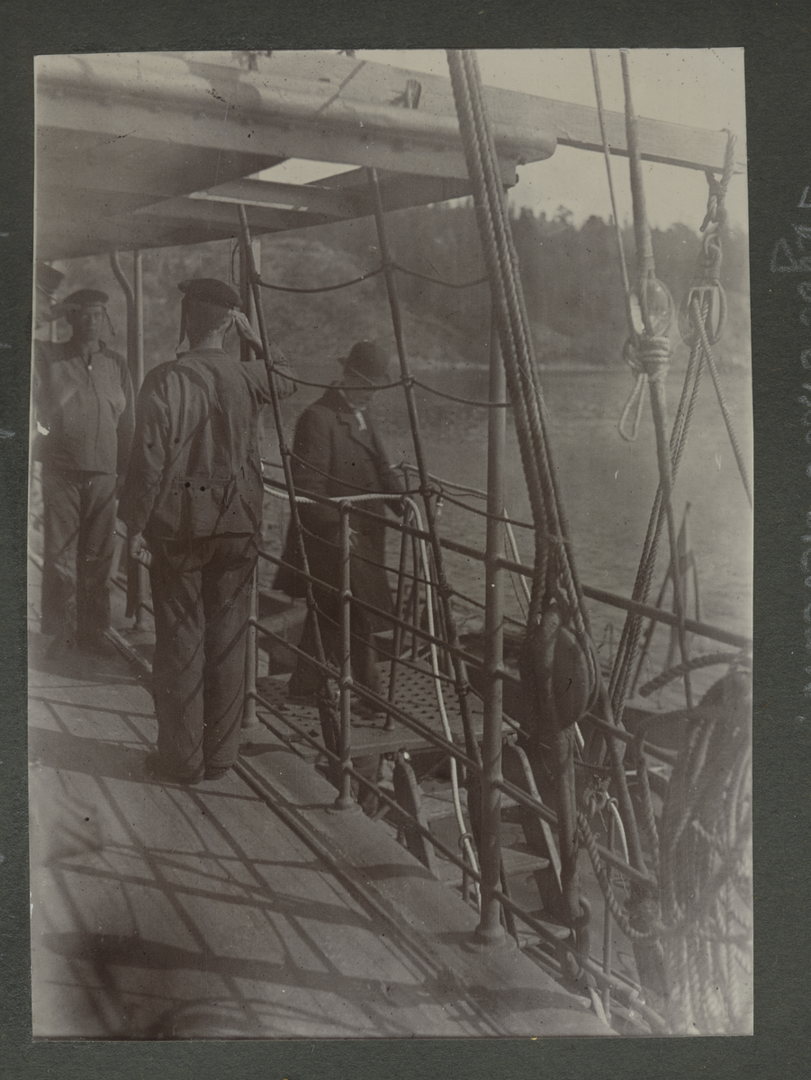 Ubåtskolan 1911. Sveriges förste civila sjöminister på besök ombord på Hvalen. Kaptenen skyms av dess periskop medan ministern är påväg ned i luckan.