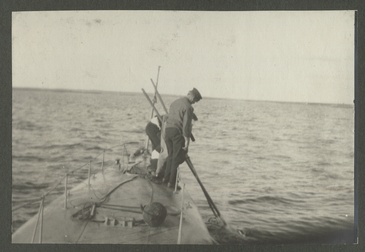 Matroser på ubåt i fart med att bogsera in en skjuten torped, Karlskrona 1914-1915.