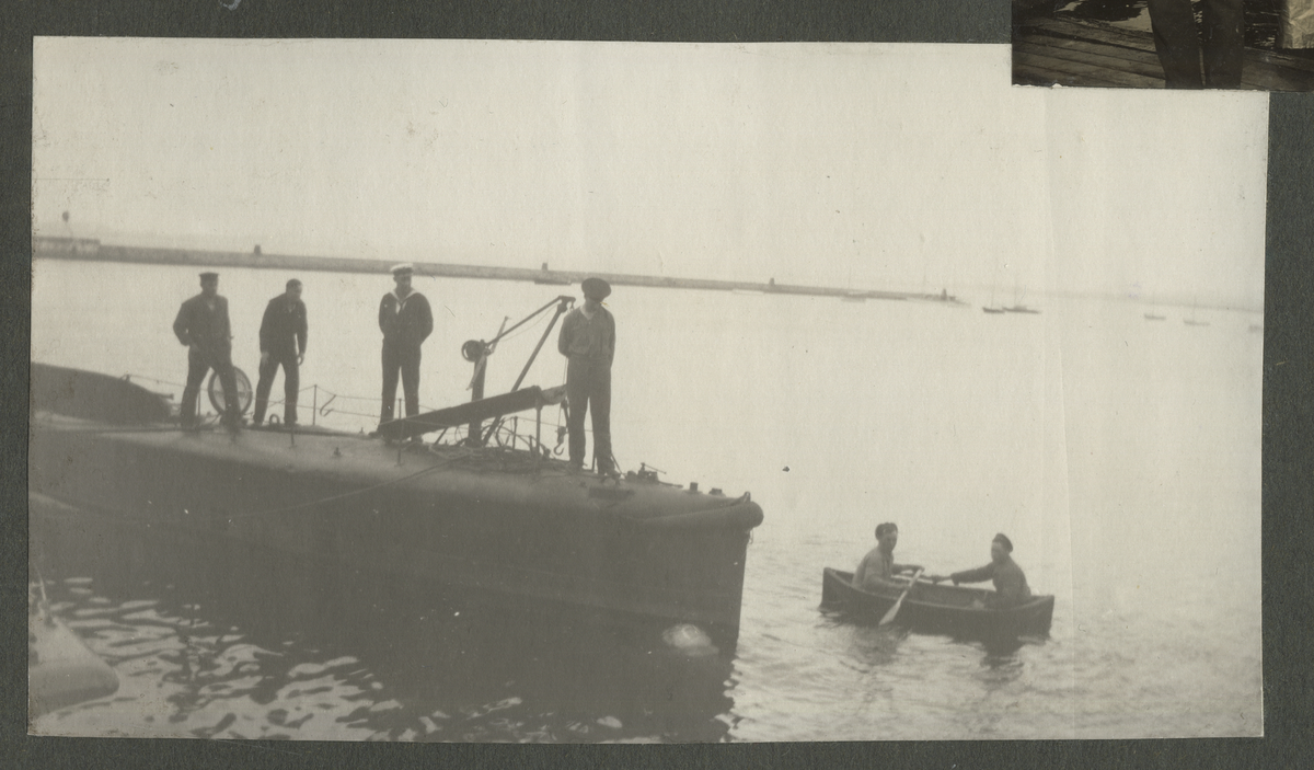 Tre män poserar framför kameran, varav en är löjtnant Netzler, aug 1917. I bakgrunden syns ett flygplan. Han störtade vid Toras Ungar i Lysekil. Avliden 15 juli 1918.