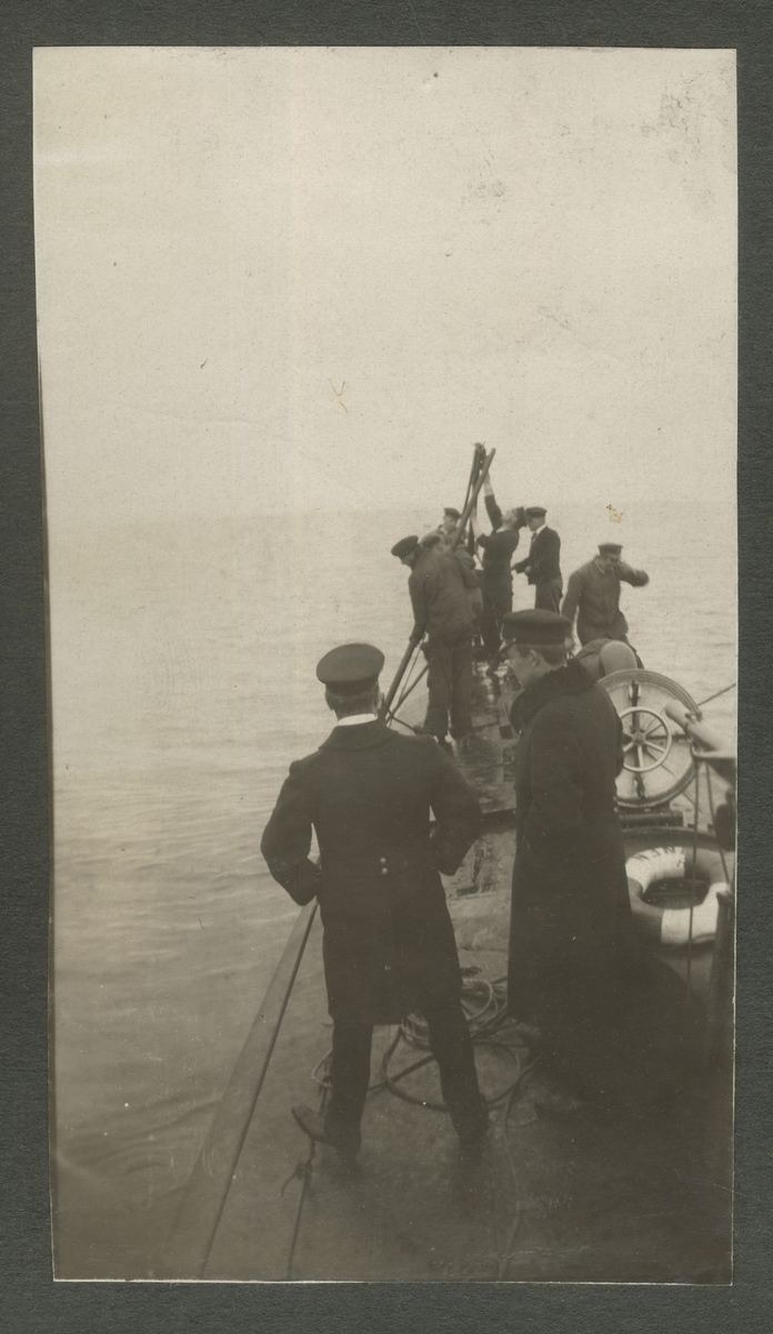 Män socialiserar på ubåtsdäck (Tumlaren) 1920. Det ser kallt ut då en av de står med händerna i fickorna.