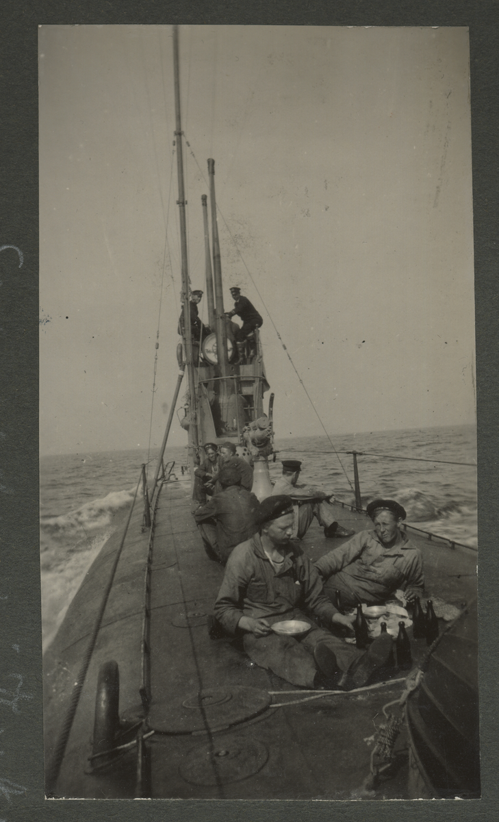 Män och unga pojkar på Sälens ubåtsdäck under provresa 1920. Två unga pojkar sitter närmast fotografen.