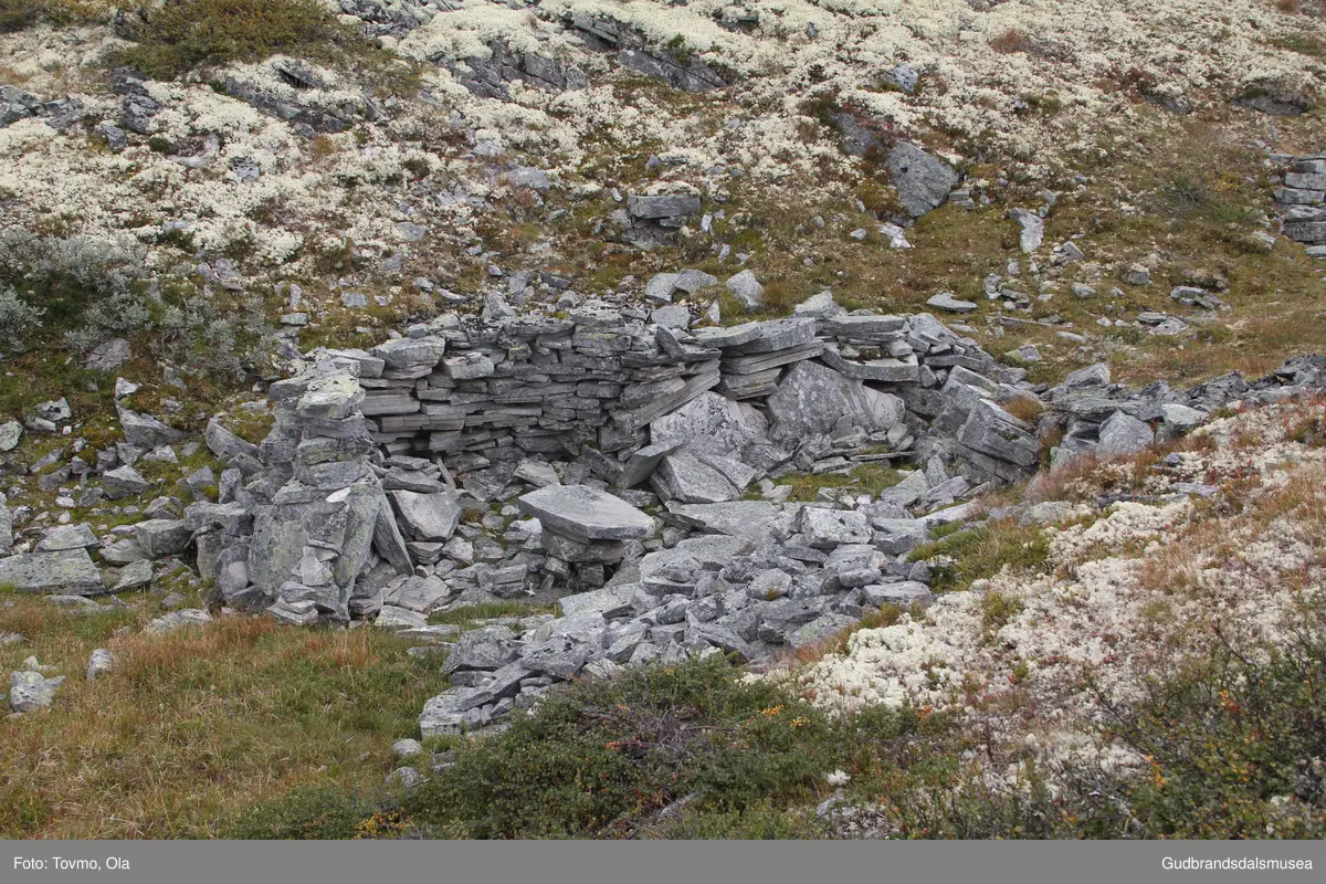 Steinmurar etter gamal bu i eit søkk på vestsida av Storrvatnet i Rondane.