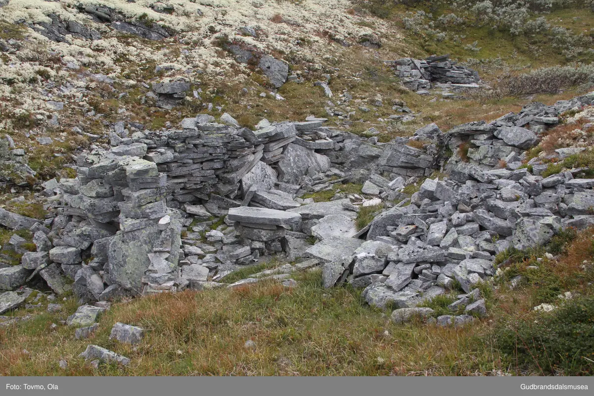 Steinmurar etter gamal bu i eit søkk på vestsida av Storrvatnet i Rondane.