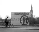 Valaffisch vid Östgötagatan inför nyvalet till riksdagen 1958. Fotot pubilcerades den 6 maj 1958.
Koalitionsregeringen mellan socialdemokraterna och centerpartiet hade upplösts på hösten 1957, varför ett nyval ägde rum den 1 juni 1958. Det var pensionsfrågan som orsakat krisen.
En man cyklar förbi en stor valaffisch för socialdeokraterna i Linköping. I bakgrunden ser man Linköpings domkyrka.
...

385 bilder om Linköping på 1950-talet från tidningen Östgötens arkiv. Framtidstro och optimism är ord som sammanfattar Linköping på femtiotalet. Årtiondet innebar satsningar för att förbättra linköpingsbornas livsvillkor. Bostadsfrågan och trafiklösningarna dominerade den lokalpolitiska agendan.
Bilderna digitaliserades år 2013.