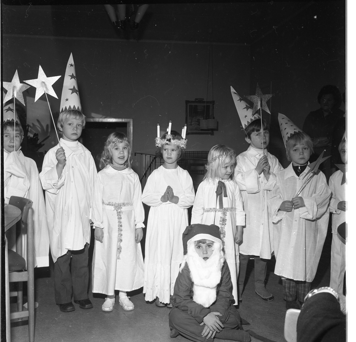 Luciatåg och stjärngossar med barn. Och en tomte.