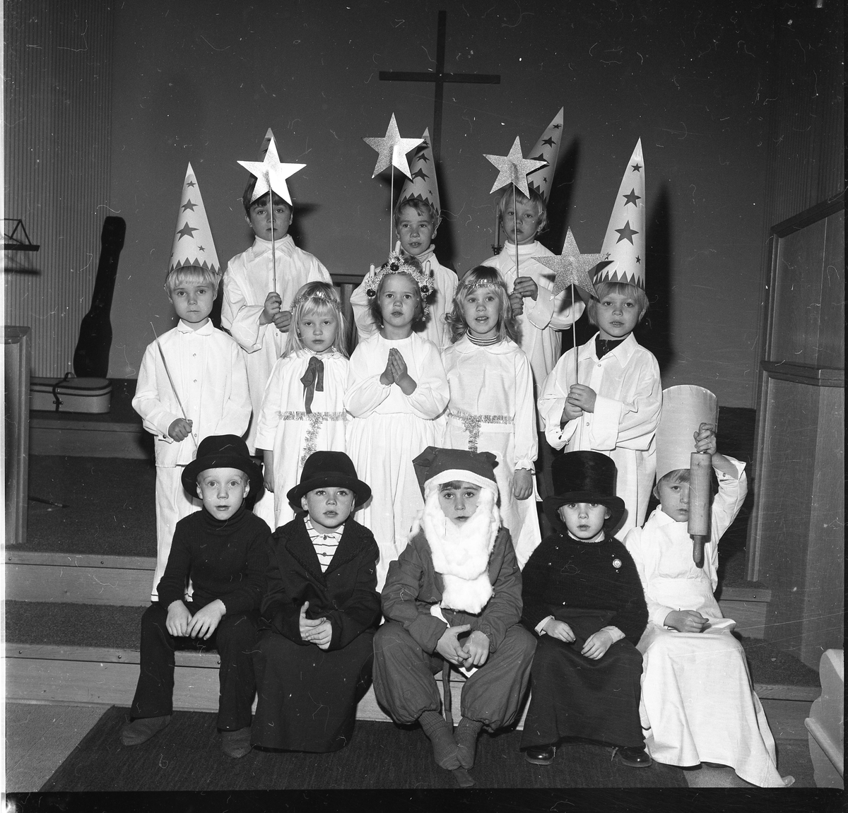 Ett luciatåg med barn, med stjärngossar, tomte och pepparkaksgubbar.