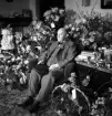 Köpman Edvard Andersson, innehavare av Bröderna Anderssons pappershandel, omgiven av blommor på sin 60-årsdag.