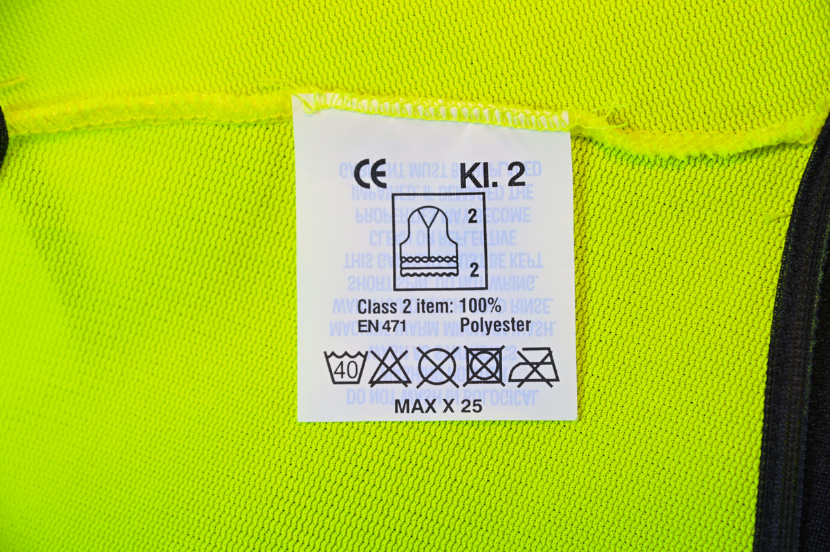 Gul reflexväst för banpersonal. Västen har två breda reflexband som går hela vägen runt och stängs framtill med kardborreband. På vänster sida om öppningen sitter en ficka och ovanför den en ögla i samma tyg som västen. Svart passpoal vid alla kantsömmar. På insidan vid vänster axel sitter en produktionsetikett med tvättråd och produktinformation.

Västen är tillverkad av Sto-Nor Industri A.S, Norge.