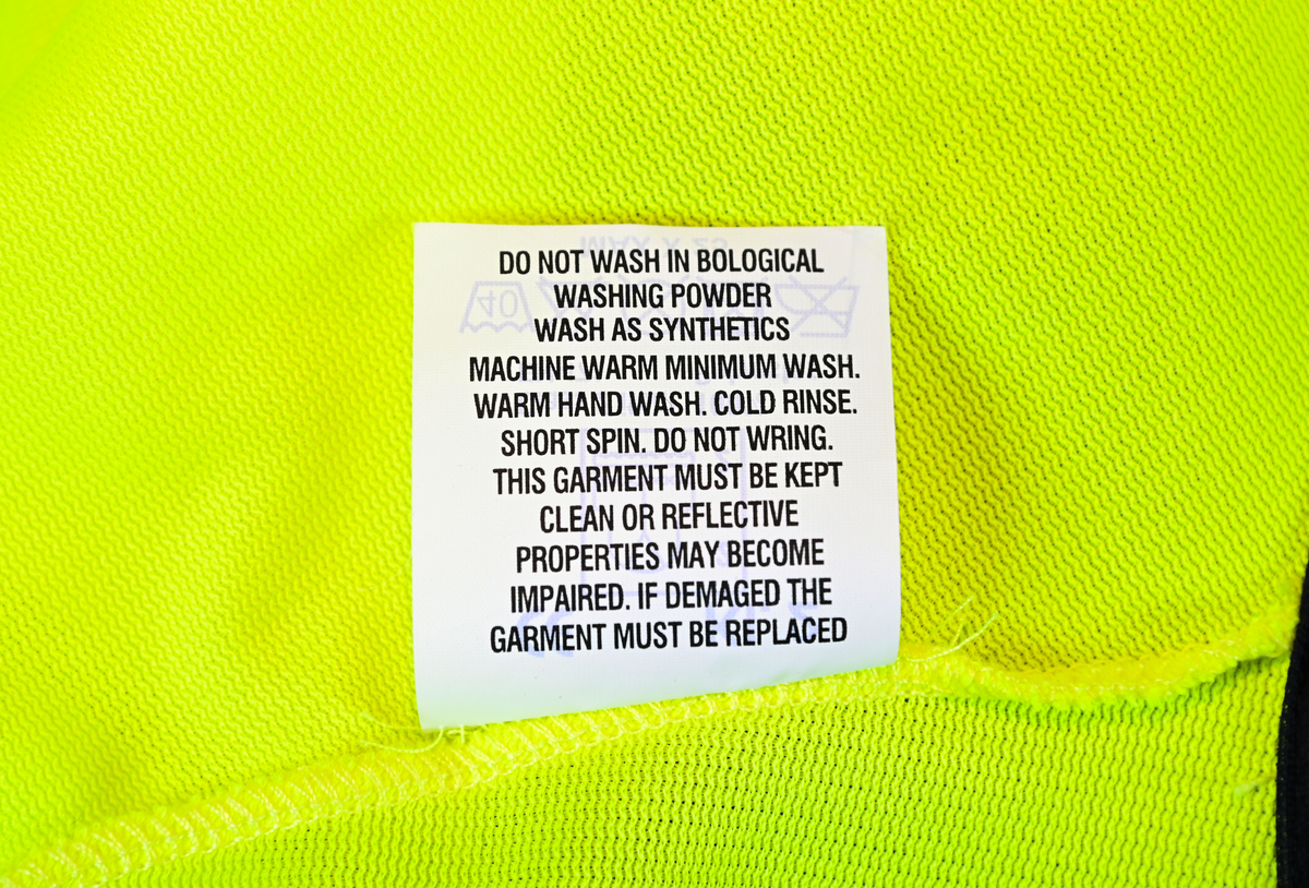 Gul reflexväst för banpersonal. Västen har två breda reflexband som går hela vägen runt och stängs framtill med kardborreband. På vänster sida om öppningen sitter en ficka och ovanför den en ögla i samma tyg som västen. Svart passpoal vid alla kantsömmar. På insidan vid vänster axel sitter en produktionsetikett med tvättråd och produktinformation.

Västen är tillverkad av Sto-Nor Industri A.S, Norge.