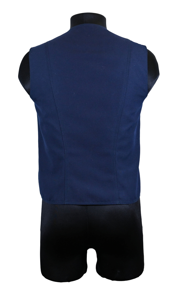 Väst till ämbetsdräkt för Luftfartsverket. Västen är av mörkblå ylle med enkel knäppning med tre stycken plastknappar. Framtill finns totalt tre stycken fickor, två midjeficor samt en bröst ficka på vänster sida. I fodret finns en innerficka på vänster sida.

Västen är tillverkad av Kommanditbolaget Björck & Co.