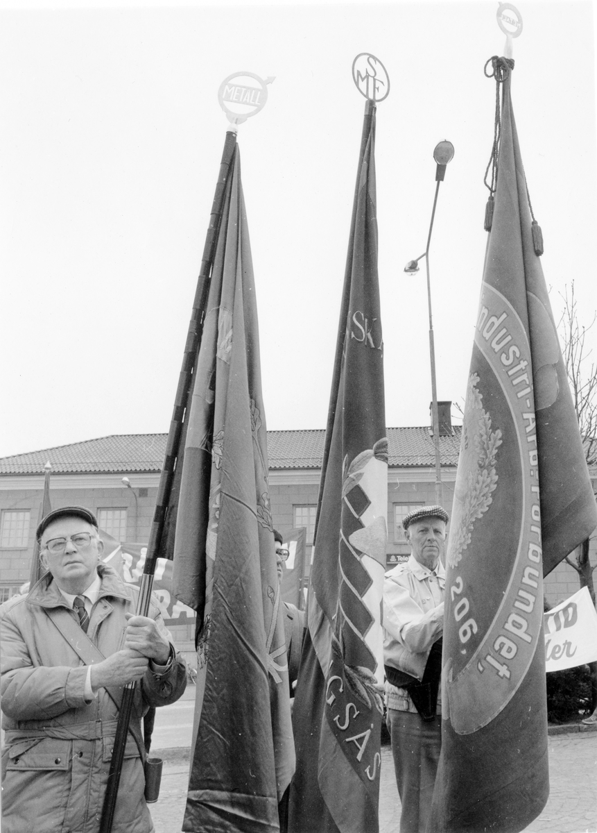 Två män med flagga ur demonstrationståget den 1:a maj på Stora Torget i Alingsås.