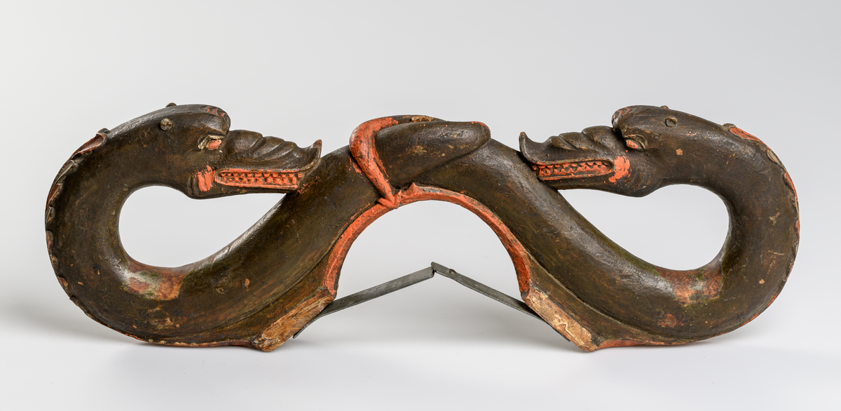 Selbåge av trä. Målad i grön, röd och brun oljefärg.
Skulptural utsmyckning: två drakar.

Inskrivet i huvudkatalog 1886.