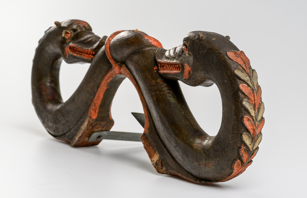 Selbåge av trä. Målad i grön, röd och brun oljefärg.
Skulptural utsmyckning: två drakar.

Inskrivet i huvudkatalog 1886.