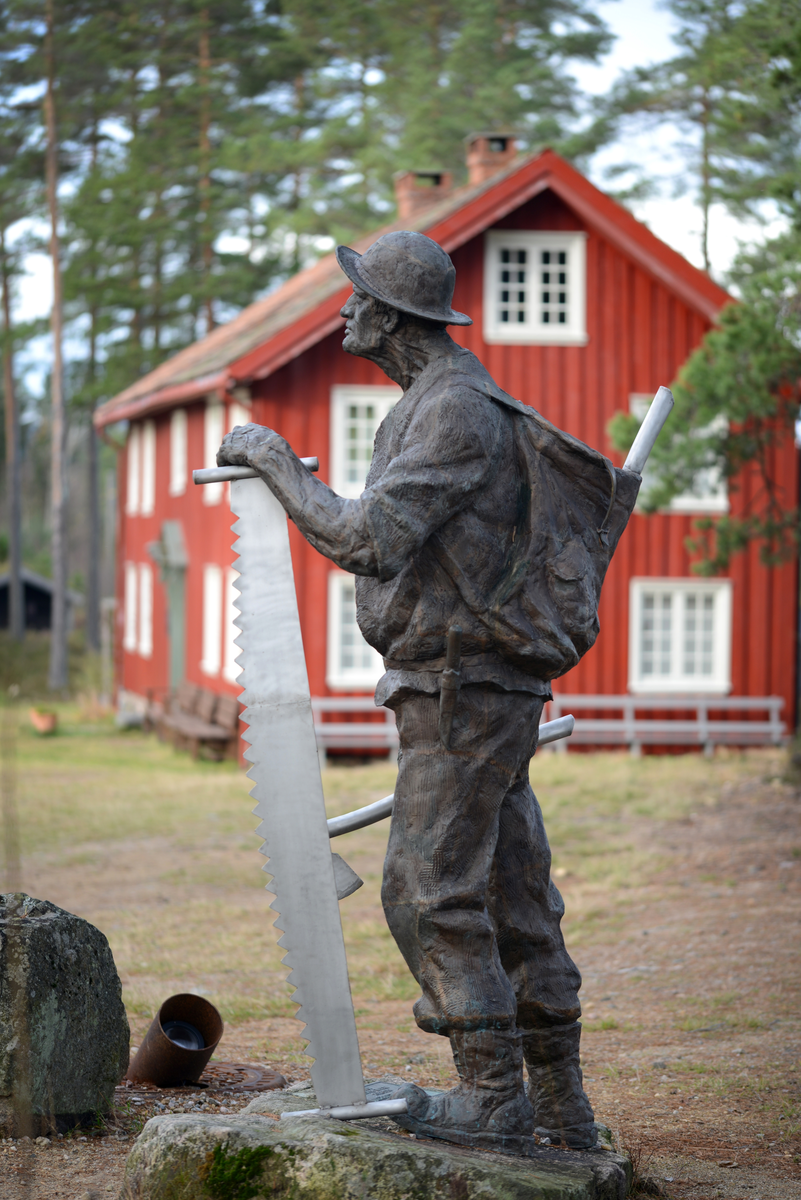Skulptur, "Skogsarbeideren" reist ved Drangedal Bygdetun i 2017. Skulpturen i bronse, er laget av kunstneren Trygve Barstad