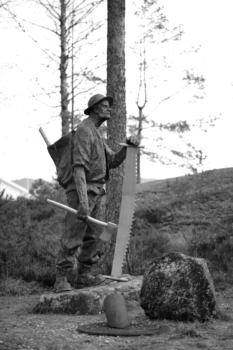Skulptur, "Skogsarbeideren" reist ved Drangedal Bygdetun i 2017. Skulpturen i bronse, er laget av kunstneren Trygve Barstad