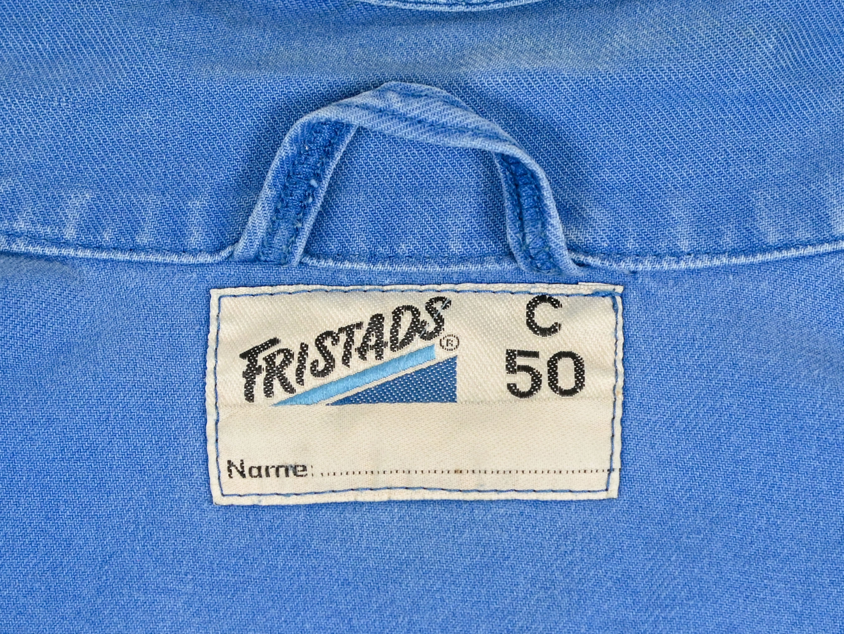 Blå arbetsoverall från SAS AB. På plagget finns en logga för SAS över vänster bröst och mitt på ryggen. Overallen har två bröstfickor med reflexband som försluts med kardborre. På framsidan under midjan sitter två större framfickor med lock och på vardera ben sitter ytterligare två fickor på sidorna. På baksidan finns två stora bakfickor. Högt upp på höger ärm sitter ytterligare en ficka av genomskinlig plast. Samtliga fickor försluts med kardborre förutom bakfickorna som stängs med plastknapp. Förutom på bröstfickorna sitter även reflexband runt benens nedre del samt högt upp över ryggen. Overallen sluts med dragkedja och två tryckknappar i metall på kragen. Vid höfterna finns två öppningar in i overallen. På knäna finns öppningar för att lägga i knäskydd.

Overallen är producerad av Fristads i storlek 50C. På lappen i nacken finns utrymme för namnteckning. På insidan av overallen vid midjan sitter en nött lapp som inte längre har någon information.

Plaggets framsida är befläckad med vit färg. Fotändar och ärmar är nötta. Flertalet mindre hål i höger ärm samt början till hål på vänster ärm.