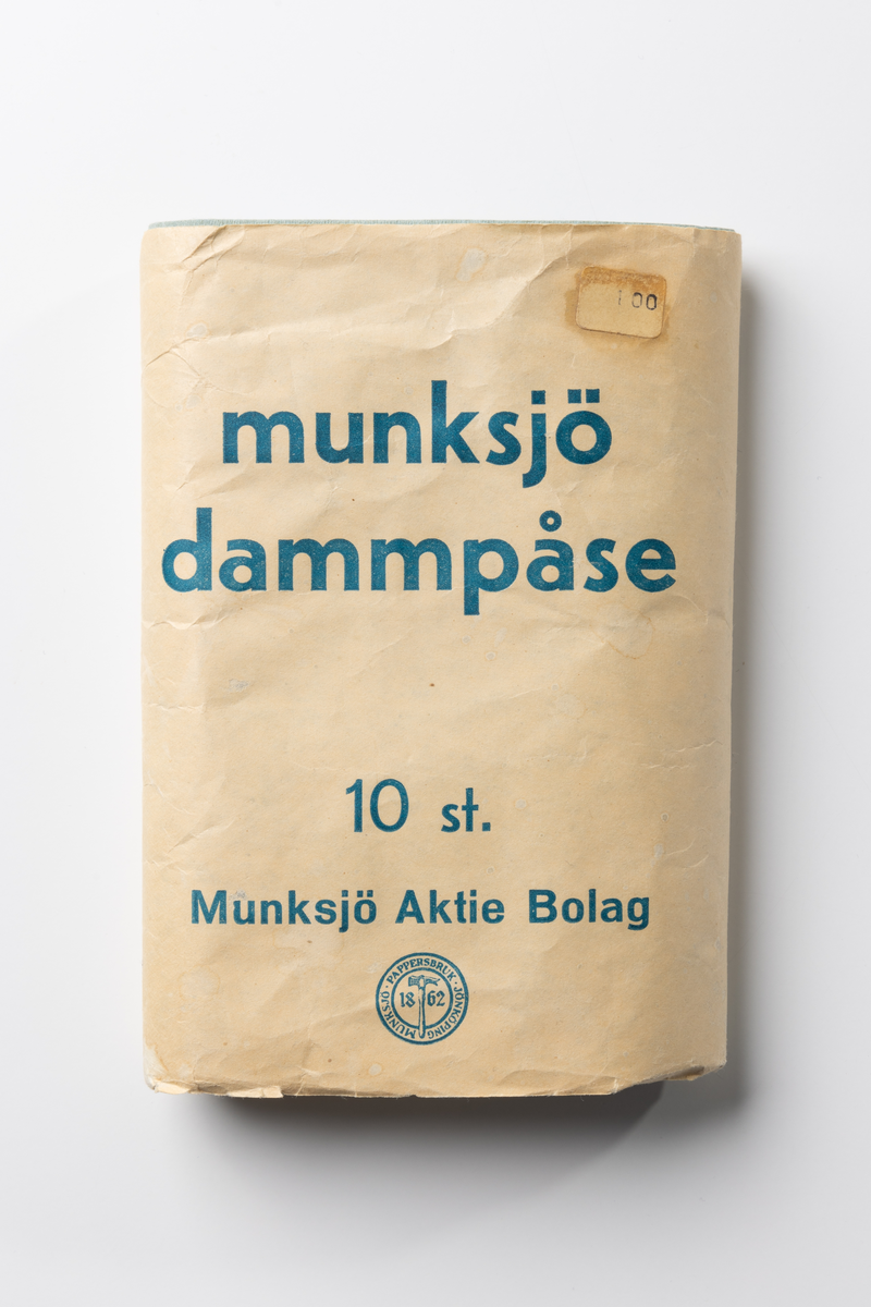 Förpackning av papper i form av en banderoll med tryckt text. Inne i förpackningen finns fem vikta oanvända dammpåsar av ljusblått papper. Förpackningen innehöll ursprungligen tio förpackningar. På banderollen tryckt blå text på ljus botten: "munksjö dammpåse 10 st. Munksjö Aktie Bolag", "PAPPERSPÅSEN PLACERAS INUTI TYGPÅSEN." Tryckt firmamärke: "MUNKSJÖ PAPPERSBRUK JÖNKÖPING 1862". Prislapp märkt 1 kr. Även papperspåsarna har tryckt text: "munksjö".

Dammpåsen av papper placerades inuti en tygpåse avsedd för dammsugare.