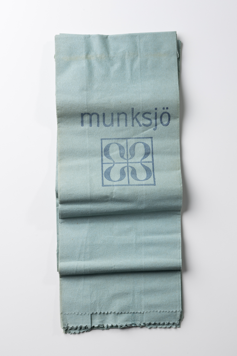 Förpackning av papper i form av en banderoll med tryckt text. Inne i förpackningen finns fem vikta oanvända dammpåsar av ljusblått papper. Förpackningen innehöll ursprungligen tio förpackningar. På banderollen tryckt blå text på ljus botten: "munksjö dammpåse 10 st. Munksjö Aktie Bolag", "PAPPERSPÅSEN PLACERAS INUTI TYGPÅSEN." Tryckt firmamärke: "MUNKSJÖ PAPPERSBRUK JÖNKÖPING 1862". Prislapp märkt 1 kr. Även papperspåsarna har tryckt text: "munksjö".

Dammpåsen av papper placerades inuti en tygpåse avsedd för dammsugare.