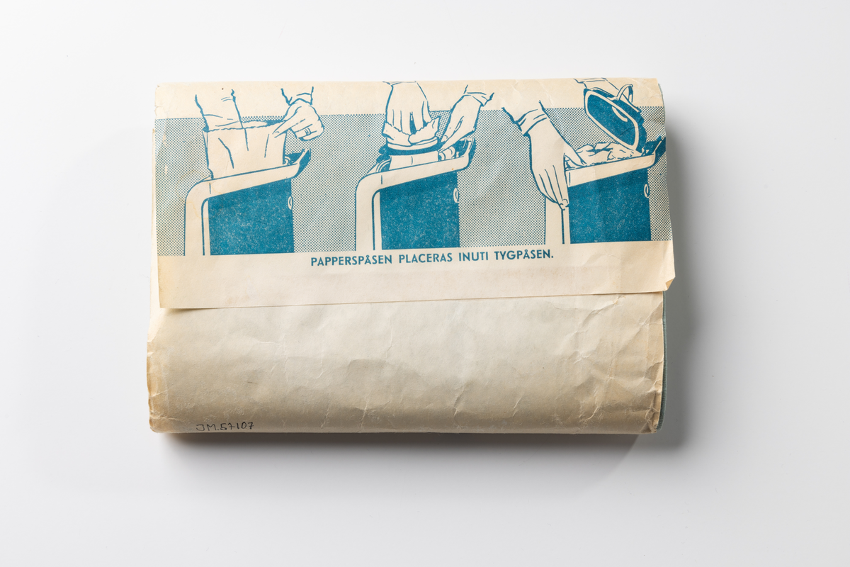 Förpackning av papper i form av en banderoll med tryckt text. Inne i förpackningen finns fem vikta oanvända dammpåsar av ljusblått papper. Förpackningen innehöll ursprungligen tio förpackningar. På banderollen tryckt blå text på ljus botten: "munksjö dammpåse 10 st. Munksjö Aktie Bolag", "PAPPERSPÅSEN PLACERAS INUTI TYGPÅSEN." Tryckt firmamärke: "MUNKSJÖ PAPPERSBRUK JÖNKÖPING 1862". Prislapp märkt 1 kr. Även papperspåsarna har tryckt text: "munksjö".

Dammpåsen av papper placerades inuti en tygpåse avsedd för dammsugare.
