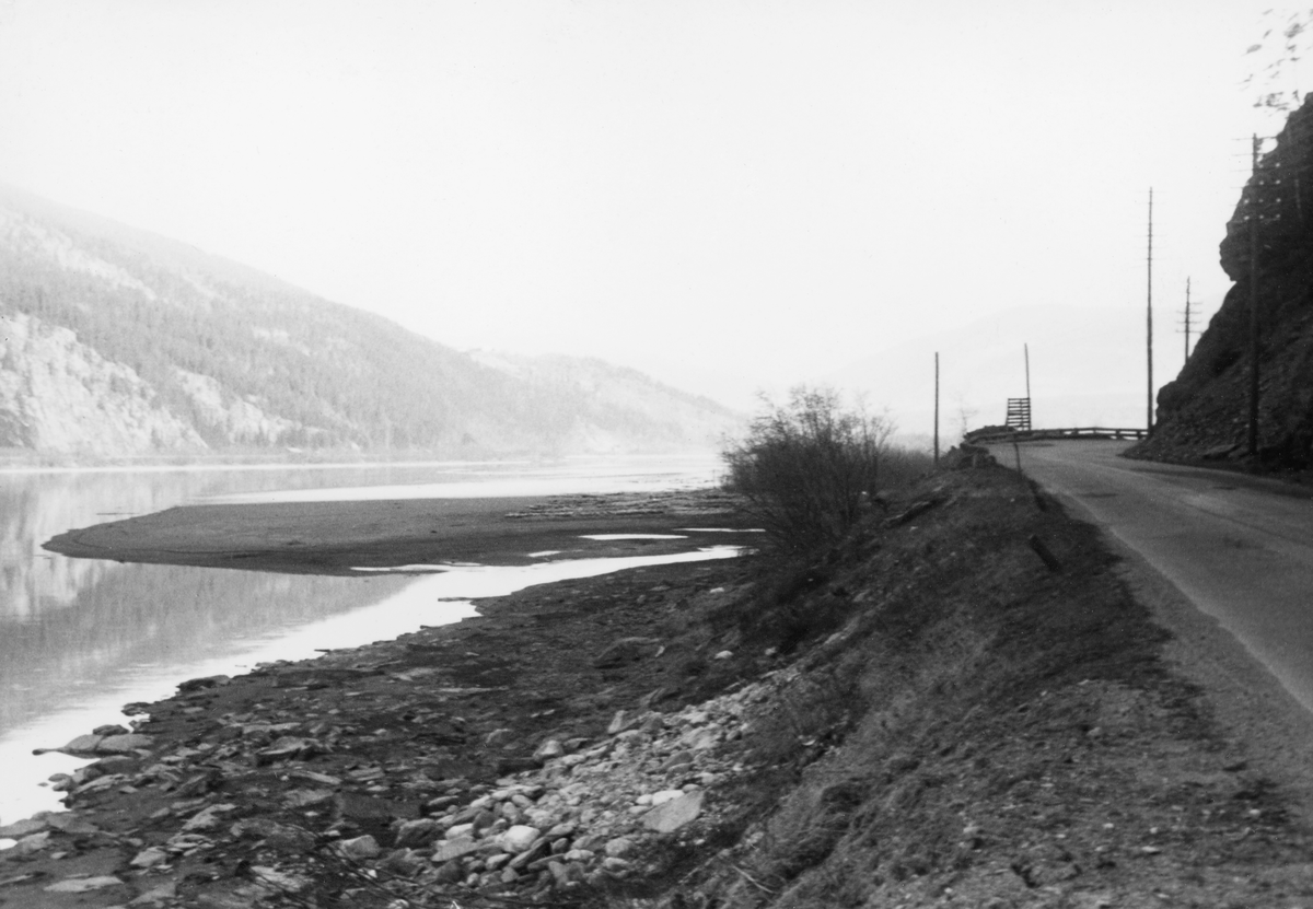 Tømmertillegging på den søndre delen av Elstadstranda, et våtmarksområde et par kilometer sør for kommunesenteret Vålebru i Ringebu i Gudbrandsdalen. Fotografiet ble tatt i slutten av april 1961, mens vannstanden i Gudbrandsdalslågen fortsatt var lav, slik at det flakveltene som lå på marka her lå tørt, innerst på en sandbanke sentralt i bildet. Dette tømmeret var lett tilgjengelig for måling, og det fikk en forsiktig tørk før flomvannet kom og løftet det med seg, noe som reduserte faren for at det endte som synke- eller søkketømmer. Fløtingsfunksjonæren som tok bildet karakteriserte derfor dette stedet som en «god velteplass». Bildet er tatt med kameraet vendt nordover, med daværende Riksveg 50 (seinere E6) til høyre i bildet. Den bratte fjellskråningen ved høyre bildekant er foten av fjellmassivet Høgkleiva. På motsatt side av elva ser vi mot Rotåslia.