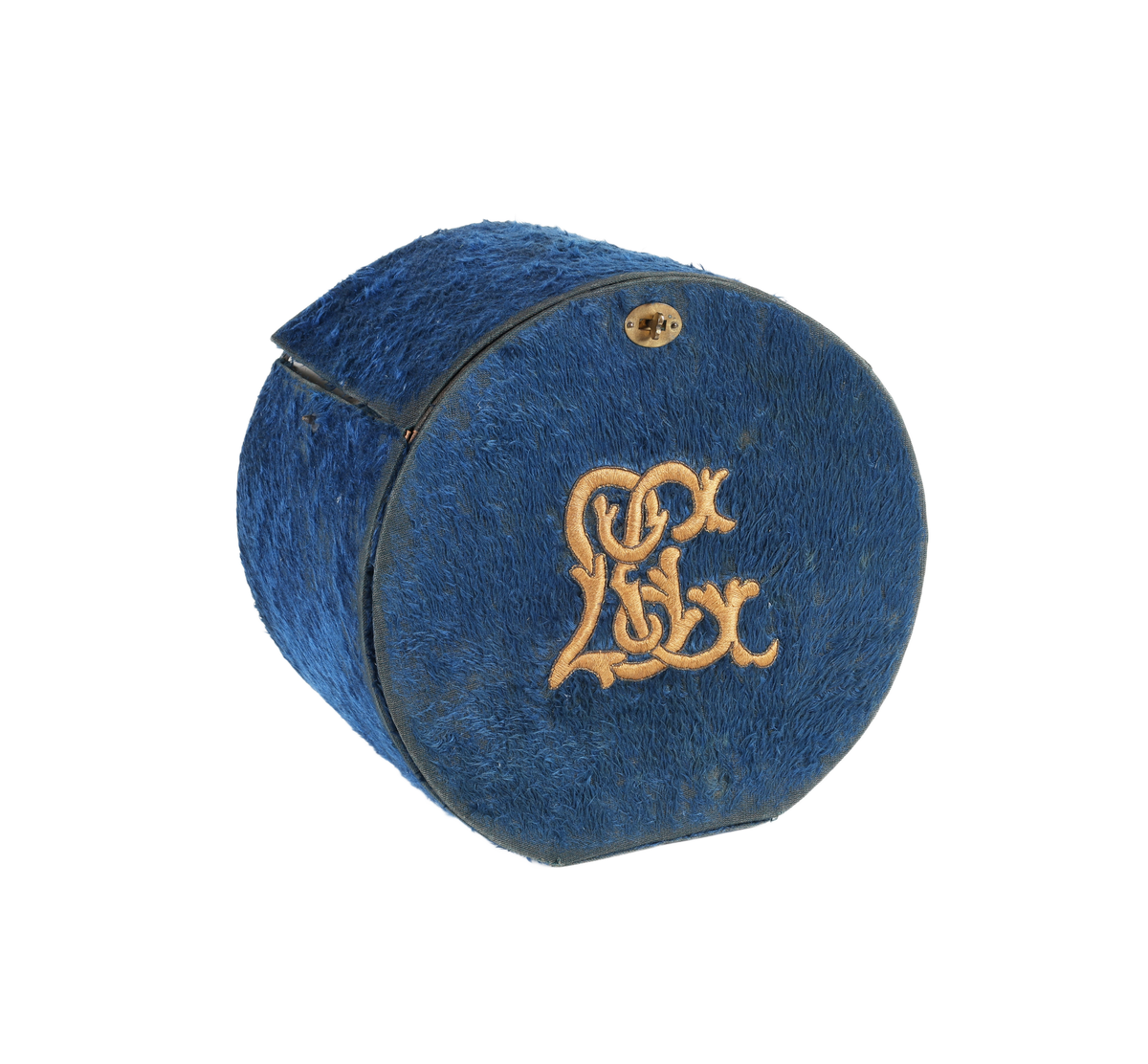 Cylindrisk ask, rak kant bak, plant lock. I framkanten lucka. Under locket cylindriskt fack för manschetter. Bakom luckan smalt cylindriskt fack för kragar. Asken klädd med plysch. På locket gulbrunt monogram i plattsöm "LC". Inuti klädd med vitt papper. Ett knäppe saknas. Bruksslitage.

Funktion: Förvaring av kragar och manschetter