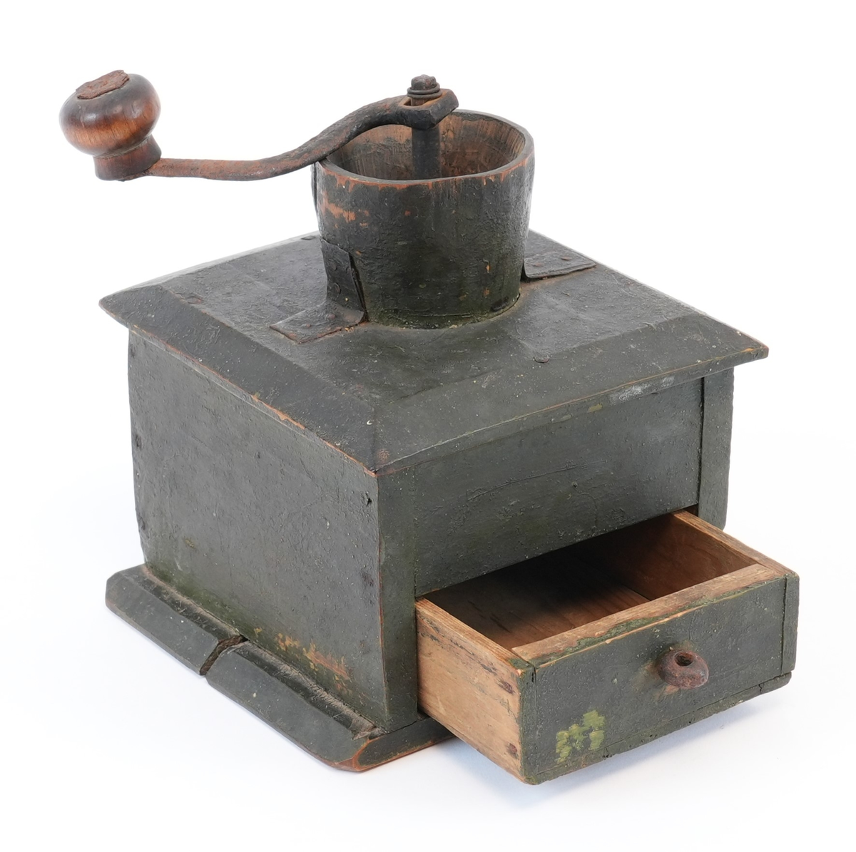 Kaffikvern. Firkanta kasse på sokkelplate, skuff med metallknott. Topplata har avfasa kantar; midt på er ein utgraven kopp til kaffibønnenen og kverna. Sveiva har treknott. Korpus måla mørk grøn utvendig.