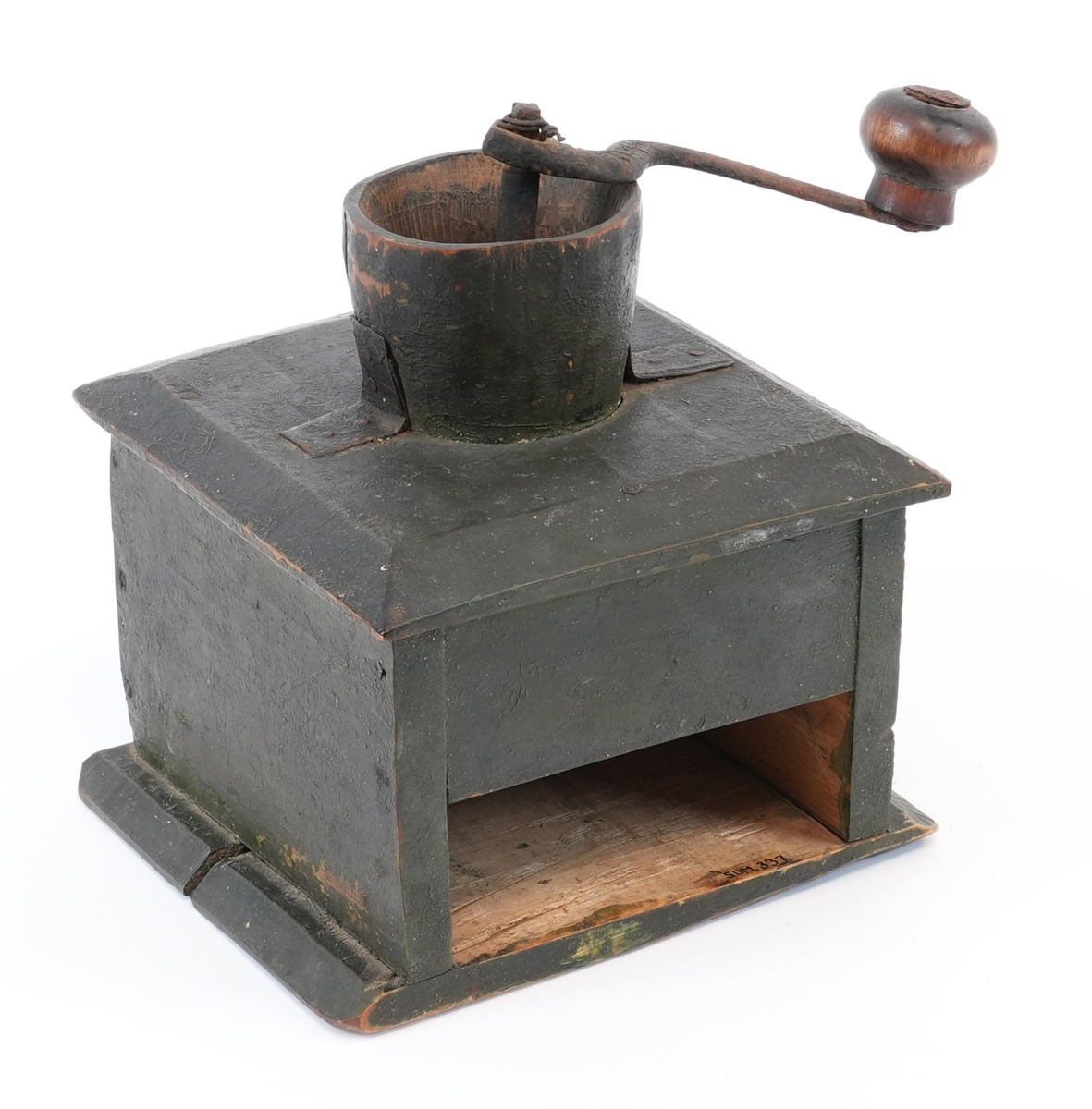 Kaffikvern. Firkanta kasse på sokkelplate, skuff med metallknott. Topplata har avfasa kantar; midt på er ein utgraven kopp til kaffibønnenen og kverna. Sveiva har treknott. Korpus måla mørk grøn utvendig.